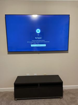 Premier TV Mounting Atl — large flat-panel TV mounted above a black media console with wires concealed