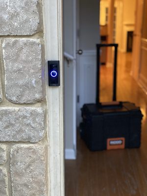 Premier TV Mounting Atl — Ring video doorbell installed on a stone entry pilaster with Ridgid toolbox staged in doorway